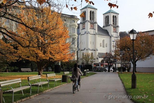 Ciclista e a igreja de St. Andrä em Salzburg