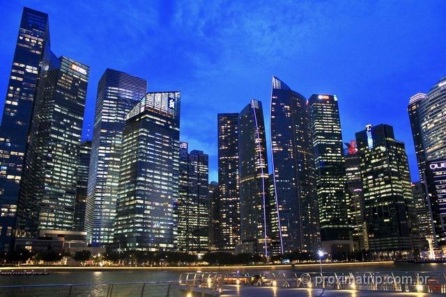 prédios iluminados ao anoitecer, em Cingapura