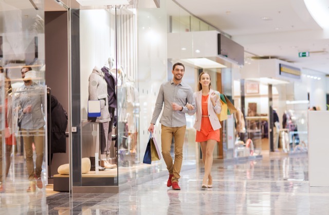 Sale consumerism and people concept happy young couple with shopping bags walking in mall